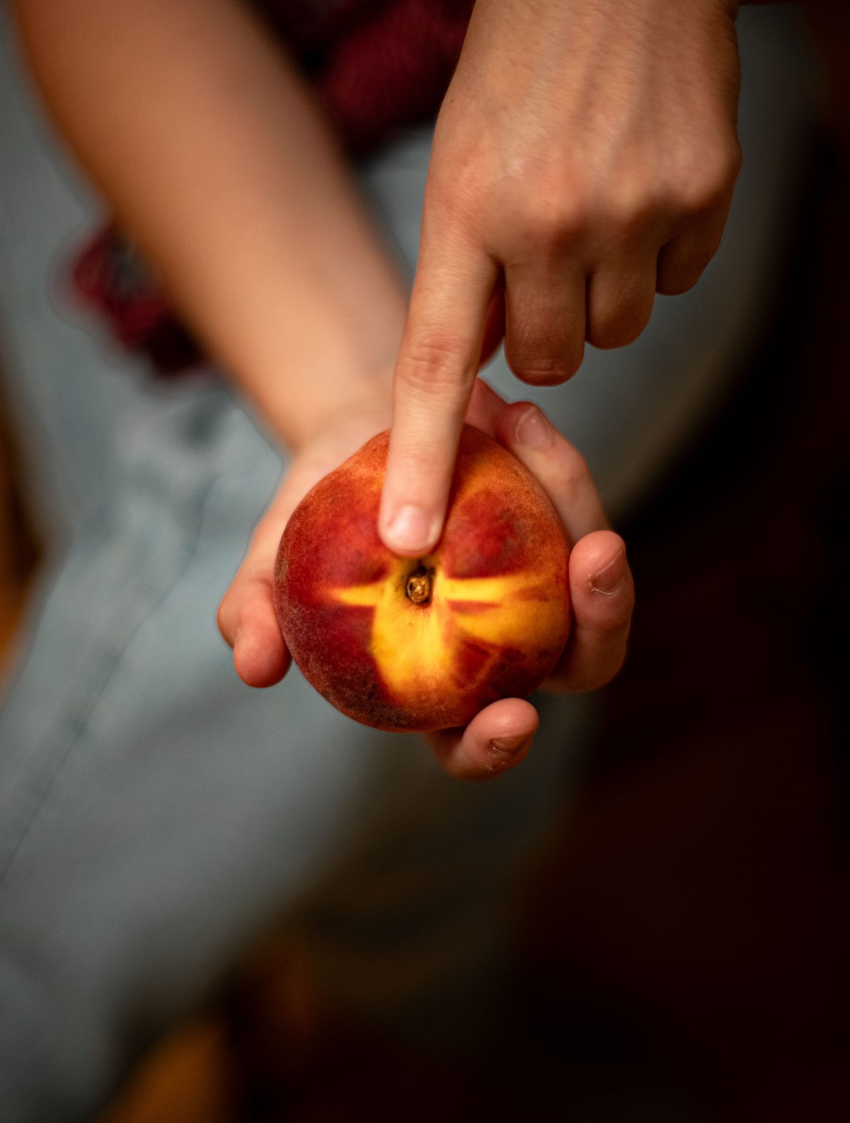 A hand holding a ripe peach